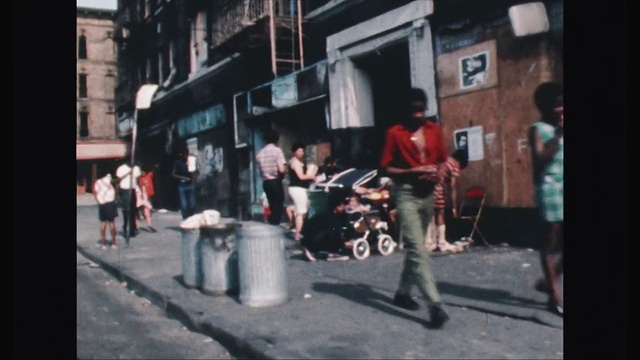 Video Reference: Photograph, People, Street, Snapshot, Neighbourhood, Town, Standing, Mode of transport, Public space, Pedestrian