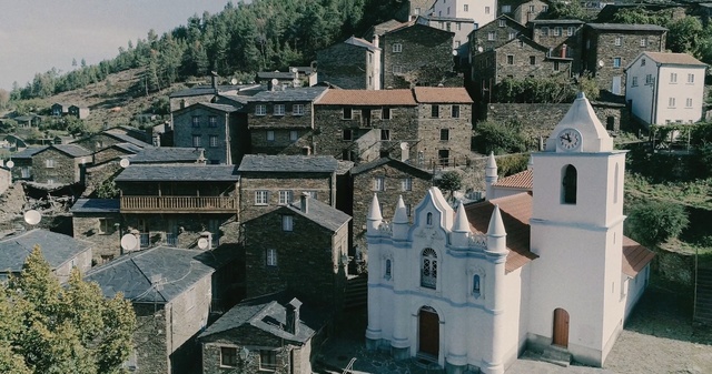 Video Reference: town, village, medieval architecture, building, city, roof, facade, tree, tourism, sky, Person