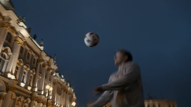 Video Reference: Sky, Night, Moon, Architecture, Cloud, Ball, World, Street light, Tourism, Person, Building, Outdoor, Man, Woman, Standing, Front, Young, Street, Girl, Holding, Clock, City, Walking, Wearing, Air, Large, Phone, People, Soccer, Flying, Tower, Church, Riding, Baseball