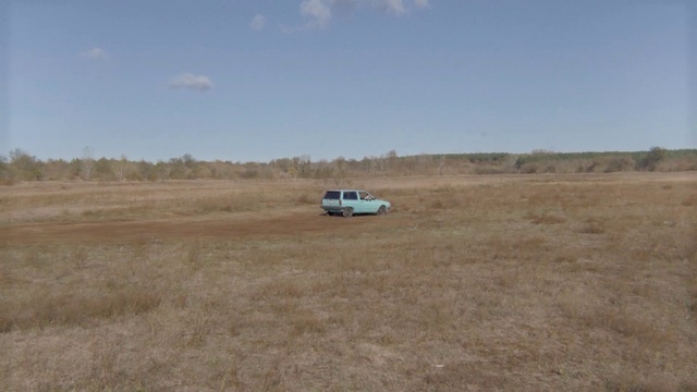 Video Reference: Plain, Ecoregion, Steppe, Natural environment, Dirt road, Soil, Grassland, Prairie, Road, Land lot, Grass, Outdoor, Field, Dry, Open, Plane, Grassy, Runway, Walking, Large, Group, Brown, Standing, Desert, Empty, Dirt, Tall, Herd, Flying, Airplane, Jet, Riding, Zebra, White, Man, Sky, Vehicle, Land vehicle, Car