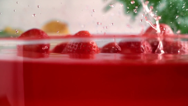 Video Reference: Red, Pink, Strawberry juice, Drink, Liquid, Pomegranate juice, Punch, Macro photography, Smoothie, Indoor, Sitting, Food, White, Rain, Small, Water, Table, Close, Blurry, Room, Display, Soft drink, Drop