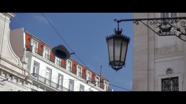 Video Reference: town, landmark, sky, light fixture, building, architecture, facade, lighting, street light, city, Person