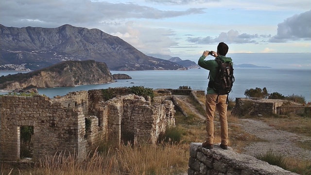 Video Reference: sky, mountainous landforms, mountain, cloud, ruins, rock, highland, tourism, hill, terrain, Person