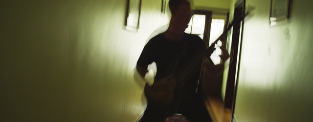 Video Reference: Black, Light, Standing, Shoulder, Shadow, Room, Photography, Muscle, Mirror, String instrument, Indoor, Person, Man, Looking, Woman, Table, Holding, Laptop, Wine, Glasses, Computer, Food, White, Kitchen, Wall, Human face