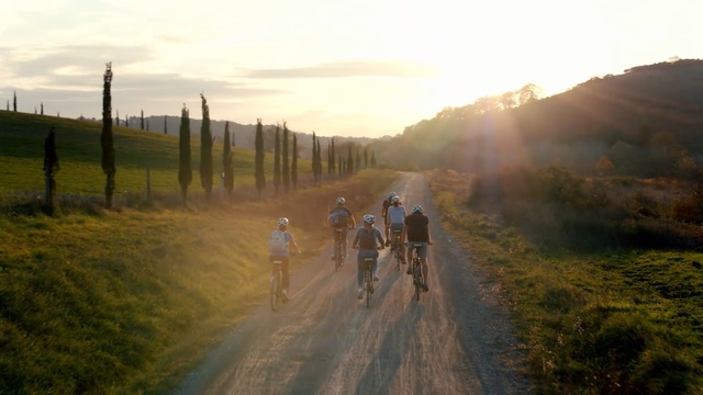 Video Reference: Morning, Cycle sport, Dirt road, Cycling, Light, Sunlight, Bicycle, Road, Vehicle, Rural area, Person