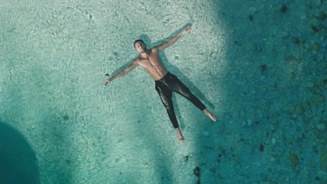 Video Reference: Turquoise, Blue, Aqua, Azure, Organism, Recreation, Building, Sport, Water, Man, Swimming, Riding, Pool, Wave, Young, Large, Board, Surfing, Air, Shirt, Standing, Doing, Jumping, Ocean, Trick, Umbrella, White, Flying, Wall, Water sport, Person, Wet suit, Ocean floor