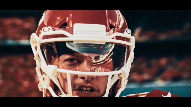 Video Reference: Sports gear, Helmet, Personal protective equipment, Football gear, Football helmet, Sports equipment, Headgear, Football equipment, American football, Player, Headdress, Indoor, Photo, Looking, Toy, Front, Cake, Sitting, Wearing, White, Close, Black, Table, Screen, Red, Hat, Woman, Holding, Man, Game, Human face, Text, Person