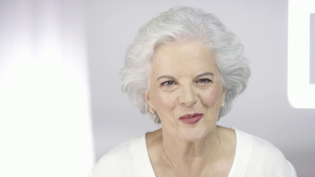 Video Reference: Face, Hair, Skin, Facial expression, Eyebrow, Chin, Lip, Blond, Head, Beauty, Person, Indoor, Woman, Clothing, White, Looking, Posing, Standing, Front, Wearing, Holding, Dress, Sitting, Shirt, Man, Mirror, Young, Smiling, Table, Kitchen, Wedding, Cake, Room, Wall, Human face, Fashion accessory, Smile, Necklace, Portrait