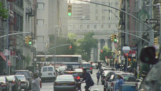 Video Reference: urban area, neighbourhood, lane, town, traffic light, city, signaling device, street, downtown, metropolitan area, Person
