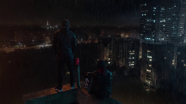 Video Reference: Night, Darkness, Light, Sky, Urban area, Atmosphere, City, Midnight, Tree, Photography, Man, Standing, Holding, Walking, Large, Water, Room, Young, Snow, Woman, Luggage, Street, People, Suitcase, Fire, Group, Clothing, Person, Skyscraper