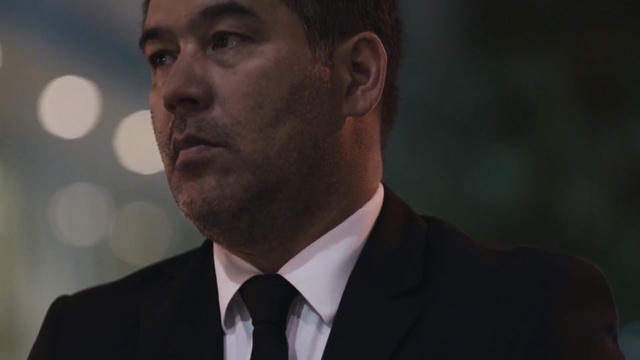 Video Reference: Suit, Facial expression, Chin, Forehead, Gentleman, Nose, Head, Formal wear, Tuxedo, White-collar worker
