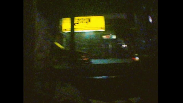 Video Reference: Mode of transport, Yellow, Light, Snapshot, Automotive lighting, Night, Automotive exterior, Darkness, Midnight, Road, Indoor, Television, Monitor, Sitting, Screen, Dark, Bus, Room, Front, Door, Red, Phone, Man, Standing, Refrigerator, Bed, Clock, Text, Car