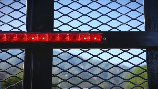 Video Reference: Chain-link fencing, Wire fencing, Iron, Mesh, Fence, Daylighting, Metal, Window, Architecture, Glass, Building, Red, Computer, Bright, Orange, Yellow, Large, Sitting, Open, Table, Train, Racket, Door, Light, Umbrella, Hanging, Keyboard, Black, Screen, Clock, Plane, Laptop, White, Court, Holding, Man, Room, Tower, Text