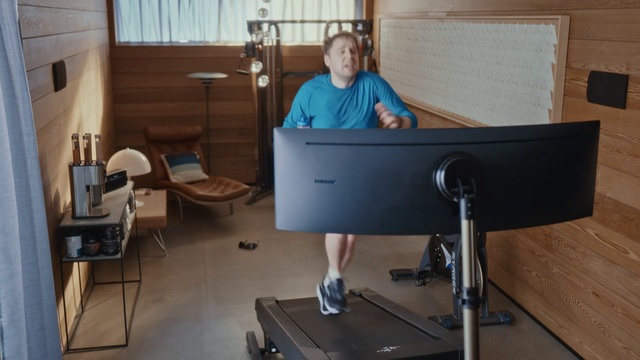 Video Reference: Desk, Standing, Furniture, Table, Room, Indoor, Sitting, Window, Computer, Woman, Front, Laptop, Black, Young, Man, Living, Holding, Kitchen, Wooden, Mirror, Playing, Bed, Dog, Video, Blue, White, Floor, Television, Sport, Computer monitor, Exercise device, Person