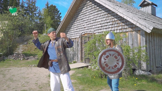 Video Reference: Man, Men, People, Shield, Hamlet, Village, Person, Outdoor, Grass, Building, Holding, Young, Standing, Ball, Playing, Boy, House, Woman, Girl, Yard, Wearing, Field, Frisbee, Park, Throwing, Air, Flying, Swinging, White, Court, Bat, Game, Street, Tree, Clothing