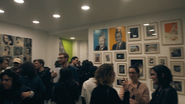 Video Reference: exhibition, art exhibition, crowd, event, vernissage, art gallery, art, tourist attraction, audience, conversation, Person
