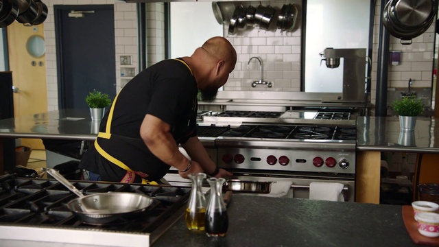 Video Reference: Cook, Cooking, Kitchen, Room, Cookware and bakeware, Food, Wok, Gas, Person, Indoor, Cabinet, Preparing, Man, Woman, Stove, Table, Window, Standing, Oven, Wearing, Counter, Pan, Young, Holding, Smiling, Large, Stainless, Computer, Plate, Pizza, White, Home appliance, Sink, Gas stove, Countertop, Microwave oven, Frying pan, Kitchen stove, Food processing, Fast food, Kitchen appliance