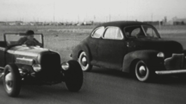 Video Reference: car, motor vehicle, vehicle, black and white, automotive design, mid size car, classic car, hot rod, automotive exterior, compact car, Person