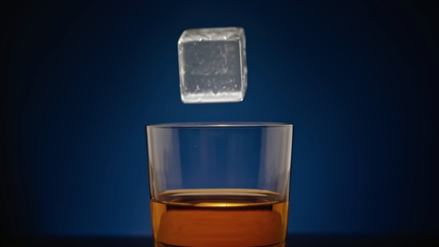 Video Reference: Water, Product, Liquid, Beaker, Glass, Transparent material, Old fashioned glass, Solution, Fluid, Glass bottle, Cup, Indoor, Table, Small, Sitting, Computer, Coffee, Laptop, Desk, Dark, Front, Keyboard, Wooden, Light, White, Monitor, Lit, Blue, Orange, Food, Bowl, Red, Holding, Vase, Drink, Soft drink, Solvent, Highball glass, Bottle, Laboratory equipment