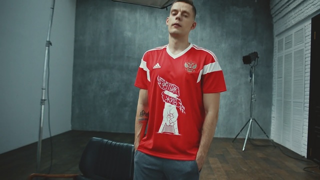 Video Reference: t shirt, red, clothing, sportswear, standing, shoulder, jersey, uniform, outerwear, leisure, Person