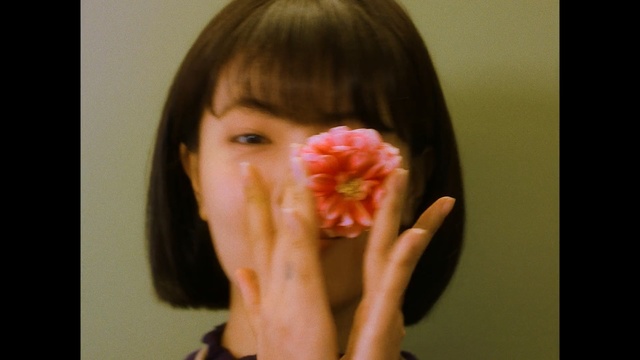 Video Reference: cheek, nose, chin, lip, finger, girl, hand, ear, mouth, flower
