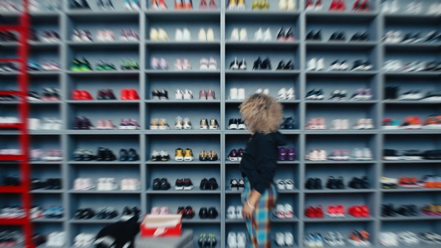 Video Reference: Shelf, Shelving, Footwear, Retail, Shoe, Shoe store, Collection, Furniture, Building, Athletic shoe, Sitting, Front, Green, Display, Red, Machine, Standing, Text