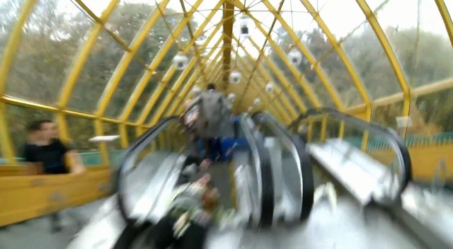 Video Reference: Amusement ride, Escalator, Amusement park, Wheel, Leisure, Nonbuilding structure, Recreation, Bicycle wheel, Spoke, Yellow, Bus, Motorcycle, Bicycle, Mirror, Riding, Sitting, School, Reflection, Table, Driving, Man, Train, Parked, Street, Engine, Standing, Playground