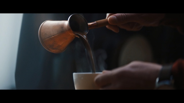 Video Reference: Drink, Drinkware, Alcohol, Person, Indoor, Hand, Using, Holding, Man, Food, Piece, Spoon, Table, Cutting, Woman, Cut, Close, Coffee, Knife, Black, Cake, Mug, Cup, Tableware, Coffee cup