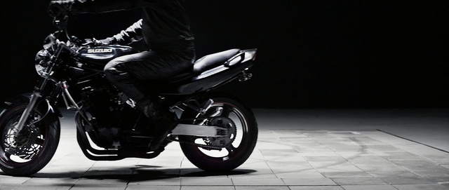 Video Reference: land vehicle, motorcycle, motor vehicle, vehicle, car, black and white, automotive lighting, automotive design, wheel, motorcycle accessories, Person