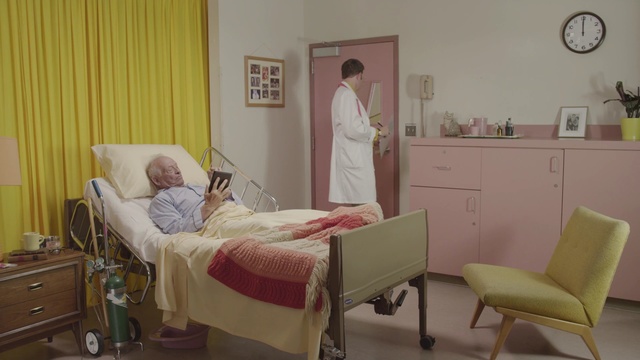 Video Reference: room, hospital, furniture, bed, product, bedroom, clinic, interior design, health care, floor, Person