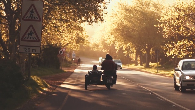 Video Reference: Mode of transport, Motor vehicle, Vehicle, Morning, Sunlight, Road, Sky, Thoroughfare, Motorcycle, Tree, Person