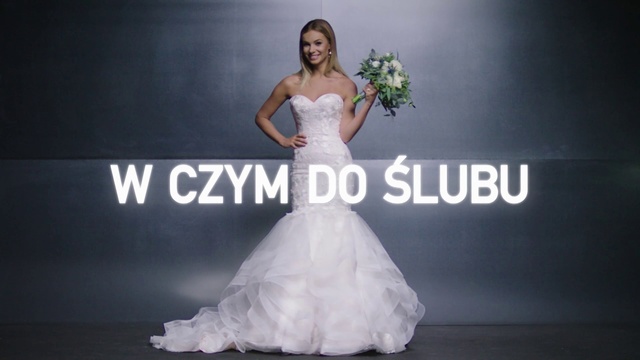 Video Reference: Gown, Wedding dress, Dress, Bride, Clothing, Bridal clothing, Shoulder, Bridal party dress, Lady, Fashion model, Person, Indoor, Woman, Standing, Front, Posing, Man, Sitting, Holding, Statue, Wearing, Large, Young, Table, White, Room, Display, Wedding, Female person, Text, Ivory, Strapless dress, Flower, Bridal veil, Haute couture, Wedding ceremony supply, Veil