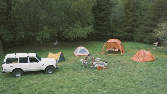 Video Reference: car, camping, vehicle, motor vehicle, grass, plant, lawn, tree, landscape, tent