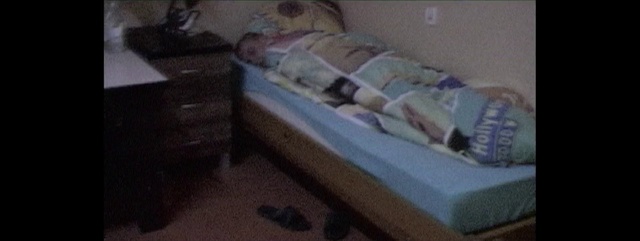 Video Reference: Bed, Furniture, Product, Mattress, Room, Property, Bed frame, Bedroom, Floor, Couch, Indoor, Sitting, Small, Messy, Window, Laying, Little, Computer, Laptop, Lying, Desk, Girl, Cat, Living, Television, Sleeping, Young, White, Blue, Stuffed, Pillow, Bed sheet, Bedding, Clothes