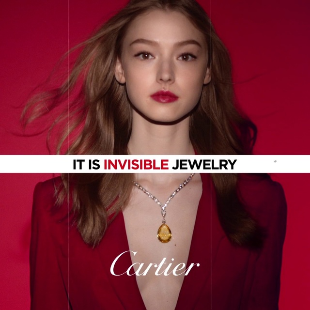 Video Reference: Hair, Face, Lip, Beauty, Red, Blond, Eyebrow, Skin, Chin, Fashion, Person, Indoor, Girl, Woman, Looking, Young, Using, Front, Holding, Sitting, Shirt, Orange, Laptop, Table, White, Wearing, Computer, Room, Yellow, Man, Standing, Fashion accessory, Necklace, Lipstick, Earrings, Human face, Cosmetics