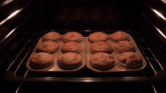 Video Reference: Dish, Food, Baking, Cuisine, Sheet pan, Ingredient, Dessert, Cooking, Baked goods, Muffin, Indoor, Oven, Cabinet, Pan, Stove, Tray, Filled, Sitting, Hot, Baked, Open, Counter, Banana, Black, Kitchen, Grill, Cooked, Pizza, Snack, Cookie, Fast food, Macaroon, Chocolate, Kitchenware, Biscuit, Cookies and crackers