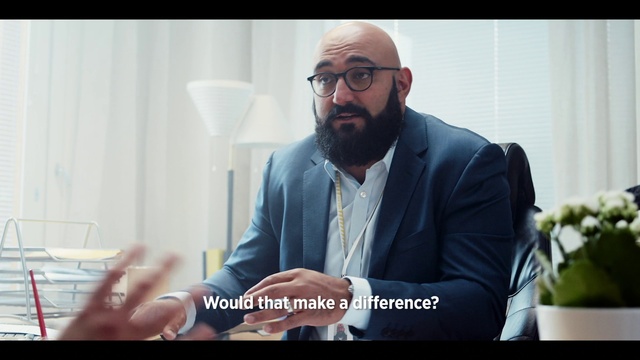Video Reference: Facial hair, Beard, Eyewear, Sitting, Glasses, Businessperson, Photo caption, Suit, White-collar worker, Vision care