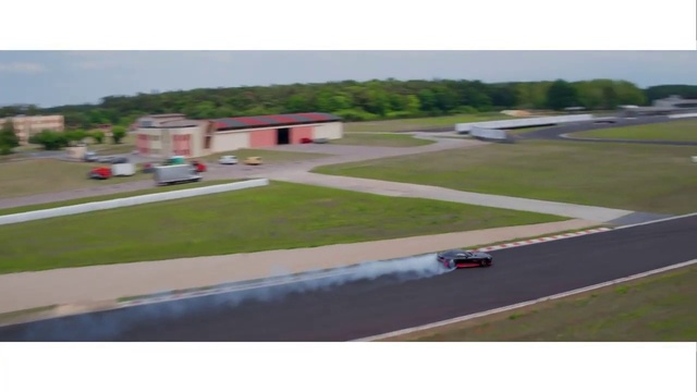 Video Reference: Race track, Sport venue, Land lot, Asphalt, Residential area, Road, Vehicle, Landscape, Building, Runway
