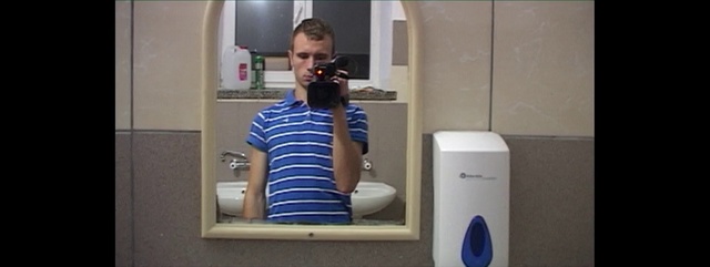 Video Reference: Shoulder, Water cooler, Selfie, Restroom, Person, Indoor, Mirror, Front, Man, Standing, Looking, Holding, Open, White, Young, Reflection, Teeth, Shirt, Mouth, Kitchen, Woman, Refrigerator, Wearing, Door, Blue, Phone, Computer, Room, Sink, Brushing, Bathroom, Plumbing fixture, Clothing, Shower, Tap, Bathtub, Home appliance, Kitchen appliance