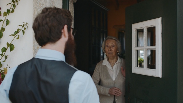 Video Reference: Formal wear, Event, Suit, White-collar worker, Conversation, Gentleman, Person, Indoor, Man, Standing, Holding, Young, Front, Looking, Woman, Video, Shirt, Room, Living, Wearing, Mirror, Boy, White, People, Wii, Playing, Game, Wall, Human face, Clothing