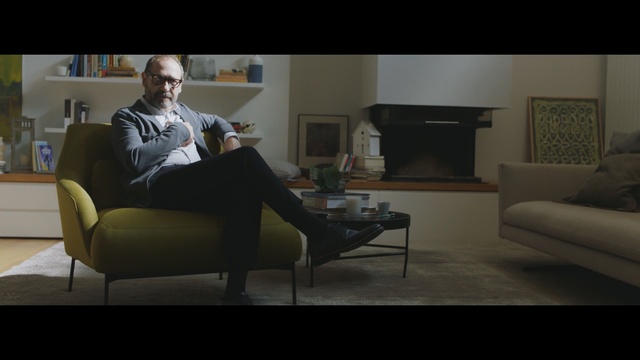 Video Reference: furniture, sitting, couch, room, table, interior design, screenshot, chair, design, home, Person