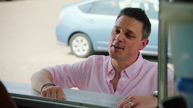 Video Reference: Smile, Vacation, Person, Sitting, Car, Man, Table, Looking, Laptop, Computer, Front, Using, Young, Food, Woman, Holding, Desk, Pink, Pizza, Room, Human face, Land vehicle, Vehicle, Wheel