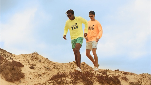 Video Reference: Sand, Fun, Vacation, Yellow, Human, Summer, Soil, Tourism, Happy, T-shirt, Outdoor, Man, Person, Mountain, Rock, Standing, Jumping, Hill, Board, Air, Riding, Snow, Rocky, Flying, Holding, Skiing, Walking, Ocean, Surfing, Water, Game, Wave, Slope, Doing, Dirt, Trick, Beach, Field, Sky, Shorts, Clothing, Day