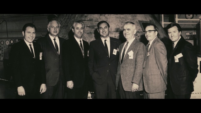 Video Reference: Photograph, Social group, Gentleman, Snapshot, Suit, Photography, Event, Formal wear, Monochrome, Team, Person, Photo, Posing, Standing, Group, Man, Front, People, Black, Window, Old, White, Woman, Wearing, Holding, Cutting, Large, Room, Smile, Human face, Clothing, Text, Tie