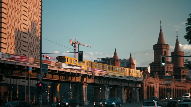 Video Reference: Metropolitan area, Urban area, City, Transport, Metropolis, Landmark, Human settlement, Sky, Town, Building, Person, Outdoor, Street, Large, Car, Train, Crossing, Traffic, Red, Long, Old, Water, Driving, Walking, Clock, Light, Riding, Traveling, White, Green, River, Bridge, Man, Tower, Standing, Track, Tall, People, Billboard