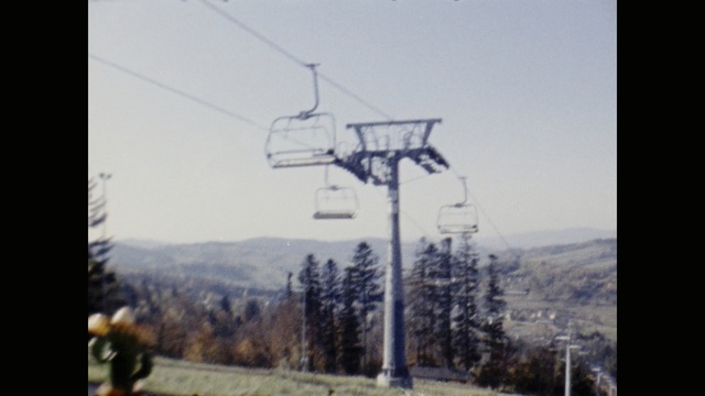 Video Reference: cable car, overhead power line, sky, electricity, hill station, electrical supply, public utility, street light, tree, mountain