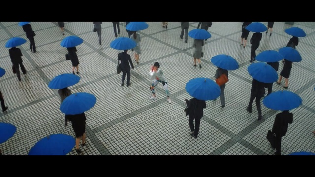 Video Reference: Blue, Umbrella, Leisure, Pedestrian, World, Crowd, Person, Small, Child, Walking, Group, Holding, People, Toy, Standing, Boy, Carrying, Little, Suit, Playing, Young, Woman, Soccer, Dog, Man, Ball, Airplane, Court, Street, Floor, Footwear, Clothing