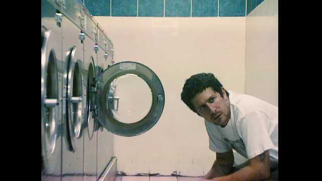 Video Reference: Cool, Photography, Man, Person, Indoor, Front, Standing, Mirror, Holding, Male, Board, Shirt, Large, Reflection, White, Doing, Clock, Human face, Text, Bathroom