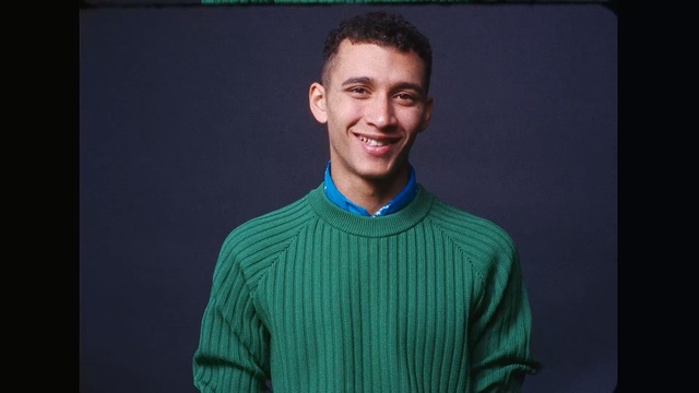 Video Reference: t shirt, chin, outerwear, shoulder, standing, smile, gentleman, human, cool, portrait, Person