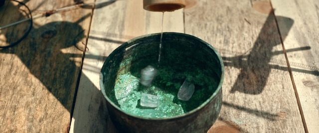 Video Reference: Water, Water well, Sphere, Circle, Person, Table, Sitting, Food, Wine, Bowl, Wooden, Plate, Stone, Glass, Red, Glasses, Green, Pizza, Standing, White, Holding, Eating, Brick, Vase, Blue, Aquarium, Meal